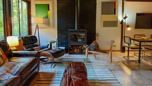 Un salon chaleureux avec une cheminée, des meubles en cuir et un coin repas.