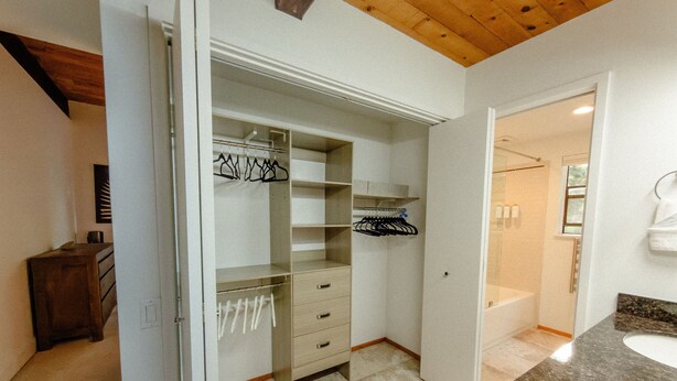 Une salle de bain avec un comptoir en marbre, un lavabo et un espace douche.