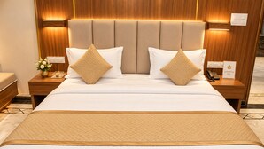 Ein Hotelzimmer mit einem großen Bett, zwei Nachttischen, einer Stehlampe und einem Schild mit der Aufschrift 'gardenia inn'.