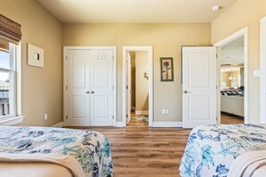 A bedroom with two beds, a hallway, and a door leading to a bathroom. - Beachy Keen- 2nd Row w/ great Views, Pool Table! 3 Bedroom, 3 Bath- Sleeps 10 (Crystal Beach)