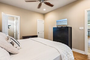 A bedroom with a bed, a ceiling fan, a dresser, and a door. - Beachy Keen- 2nd Row w/ great Views, Pool Table! 3 Bedroom, 3 Bath- Sleeps 10 (Crystal Beach)