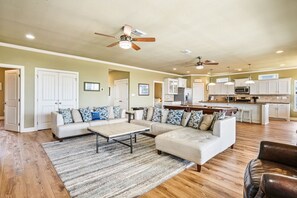 A spacious living area with a sofa set, a coffee table, and a kitchen in the background. - Beachy Keen- 2nd Row w/ great Views, Pool Table! 3 Bedroom, 3 Bath- Sleeps 10 (Crystal Beach)