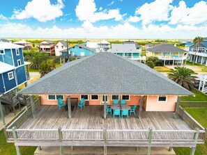 A beachfront house with a wooden deck, outdoor seating, and a view of the ocean. - Beachy Keen- 2nd Row w/ great Views, Pool Table! 3 Bedroom, 3 Bath- Sleeps 10 (Crystal Beach)