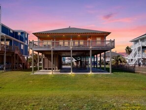 A two-story building with a covered patio and a staircase leading to the upper level. - Beachy Keen- 2nd Row w/ great Views, Pool Table! 3 Bedroom, 3 Bath- Sleeps 10 (Crystal Beach)