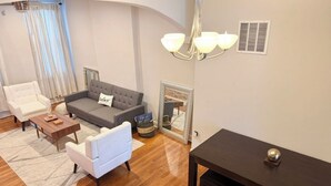 Ein stilvolles Wohnzimmer mit einer Couch, Sesseln, einem Couchtisch und einem dunklen Holztisch.