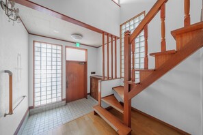 A wooden staircase with a handrail and a door with a window. - HARMONY OTARU (Otaru)