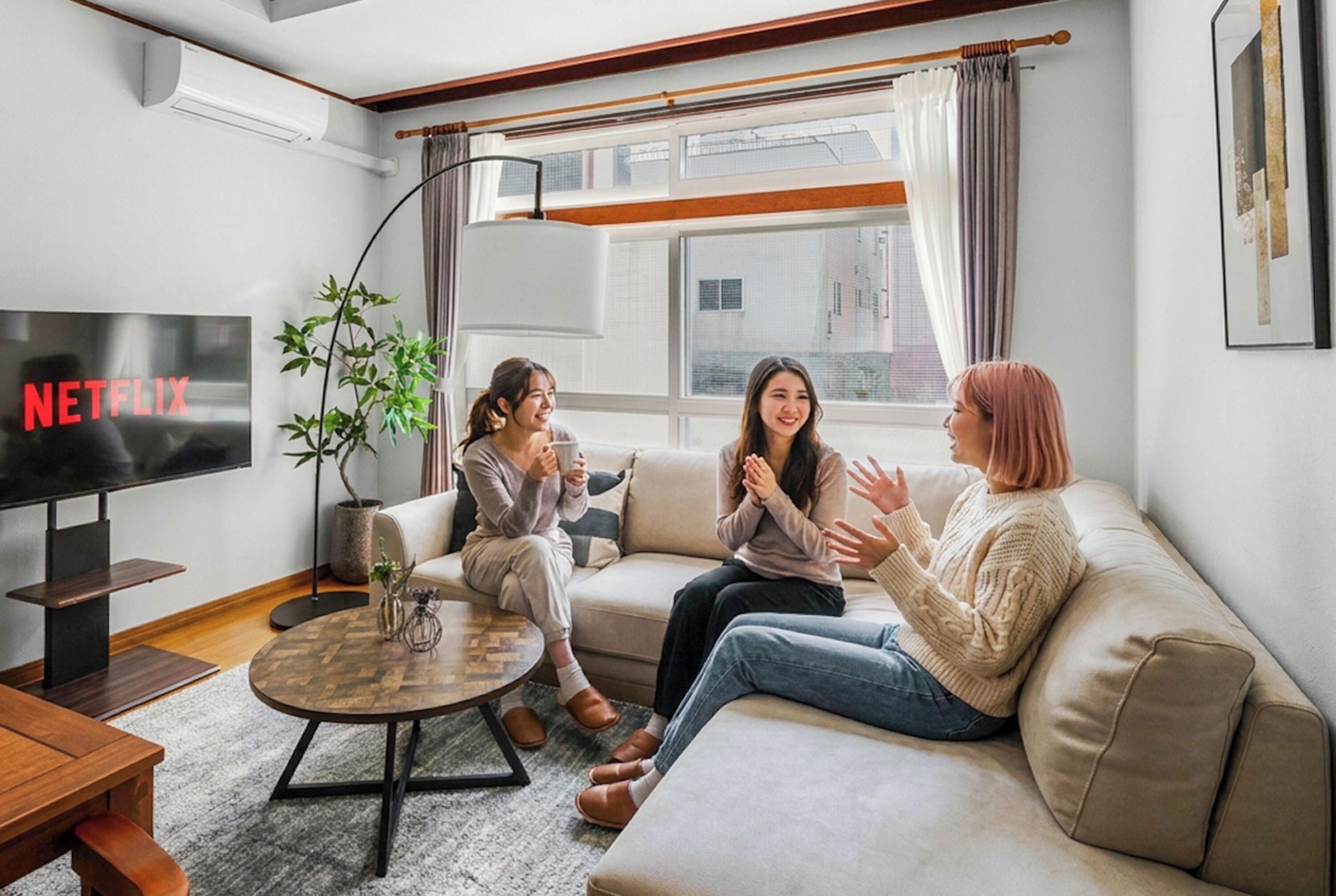 Una sala de estar con televisor, una mesa de centro y un sofá.