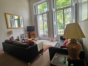 Ein Wohnzimmer mit Sofa, Couchtisch, Fernseher und Lampe.