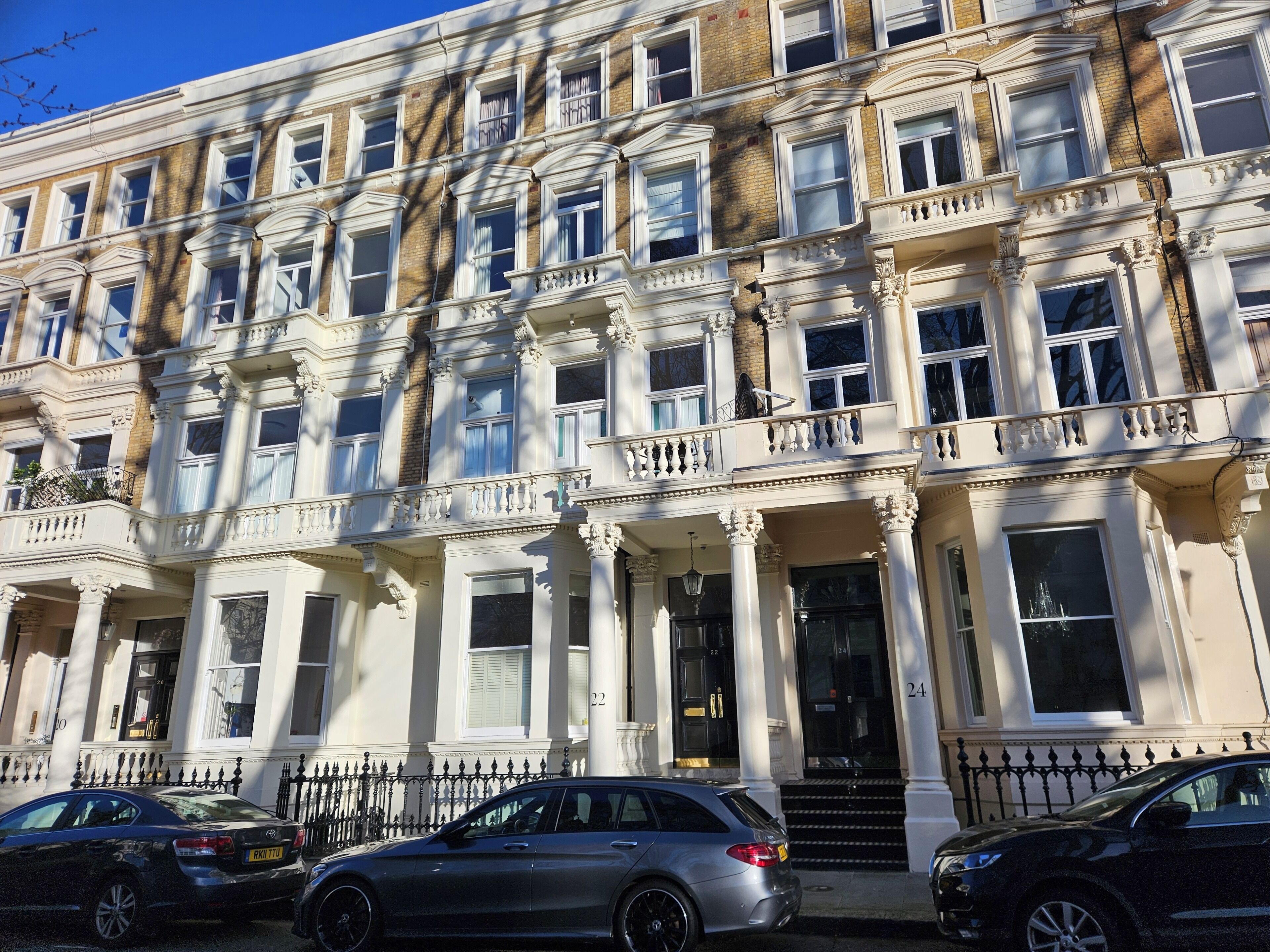 A row of townhouses with a classic architectural style, featuring multiple windows and balconies.