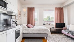 Un dormitorio moderno con una cama, un televisor y un sofá.