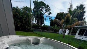 Un jacuzzi con vistas despejadas al jardín y los árboles circundantes.