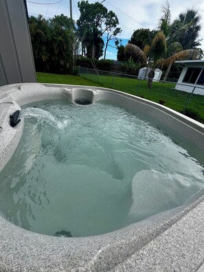 Ein Whirlpool mit freiem Blick auf den umliegenden Garten und Bäume.