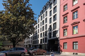 A multi-story building with a modern architectural style, featuring a mix of brick and painted facades. - RentPlanet - Jodłowa Residence (Wrocław)