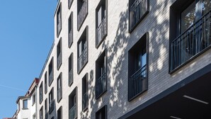 A multi-story building with a modern architectural style, featuring a series of balconies and windows. - RentPlanet - Jodłowa Residence (Wrocław)