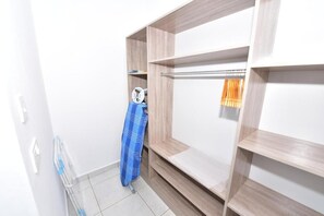 Un armario vestidor con estantes abiertos y una barra para colgar ropa.