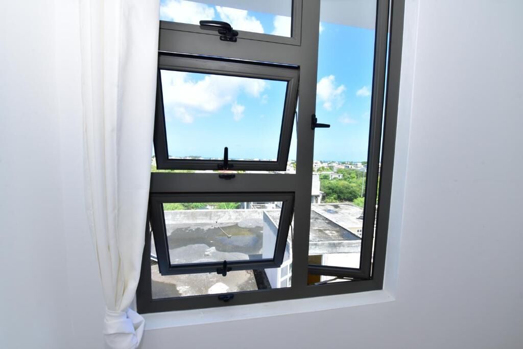 A window with a view of a rooftop and buildings.