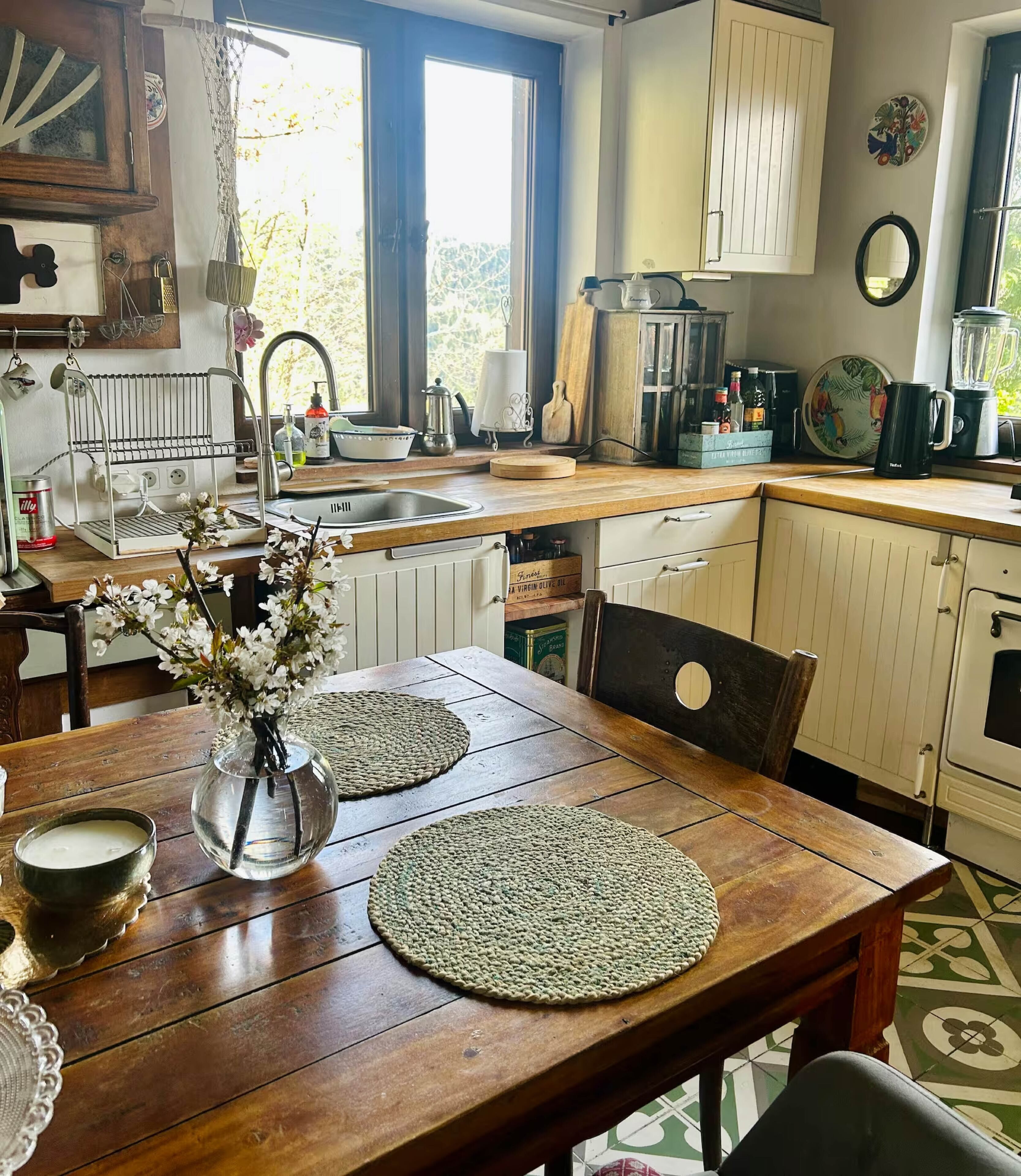 A kitchen with wooden cabinets, a sink, and a dining table with placemats.