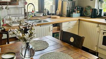 A kitchen with wooden cabinets, a sink, and a dining table with placemats.