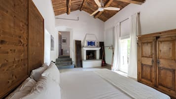 Une chambre à coucher avec un grand lit, une armoire en bois et un ventilateur de plafond.