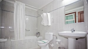 Ein Badezimmer mit Badewanne, Toilette und Waschbecken.