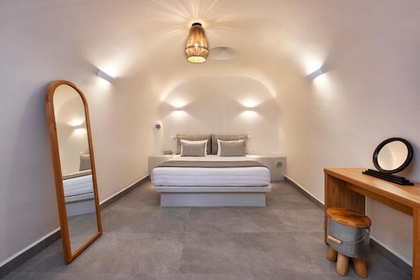 Un dormitorio con cama, mesita de noche, espejo y lámpara colgante.