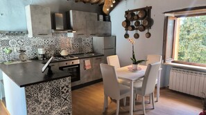 Une cuisine avec coin repas, dotée de carreaux décoratifs, d’une cuisinière et d’une fenêtre offrant une vue agréable.