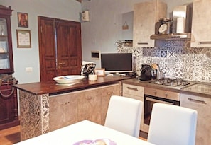 A kitchen with a central island, a stove, and a dining table with chairs. - Casa al Poggio. An 18th-century farmhouse in Val d'Orcia. Perfect for families (Castiglione d'Orcia)