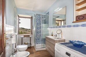 Une salle de bain avec des toilettes, un lavabo et une douche.