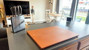 A kitchen counter with a cutting board, a knife block, and a small figurine. - Waterfront patio 2 bedroom condo (Sandusky)