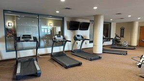 A gym with treadmills, a stationary bike, and a rowing machine. - Waterfront patio 2 bedroom condo (Sandusky)