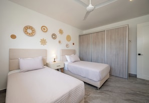 A hotel room with two beds, a ceiling fan, and a wardrobe. - 3BR Surfside Home with Large Pool & BBQ (Playa Potrero)