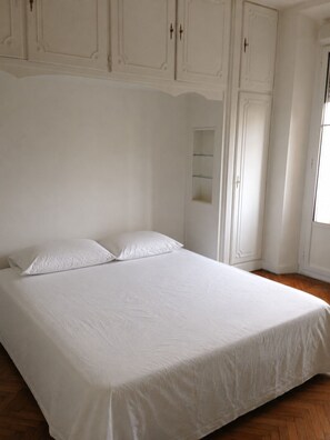 A bedroom with a single bed, white walls, and wooden flooring. - Charming 2-bedroom apartment with AC in beautiful Cannes (Cannes)