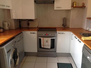 A compact kitchen with a built-in oven, a washing machine, and a dishwasher. - Charming 2-bedroom apartment with AC in beautiful Cannes (Cannes)