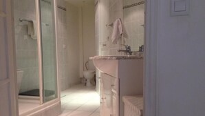 Ein Badezimmer mit Duschkabine, Waschbecken und Toilette.