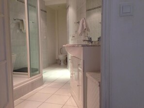 A bathroom with a glass-enclosed shower, a sink, and a toilet. - Charming 2-bedroom apartment with AC in beautiful Cannes (Cannes)