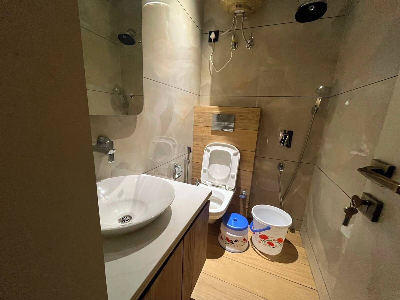Un baño moderno con lavamanos, inodoro y ducha.