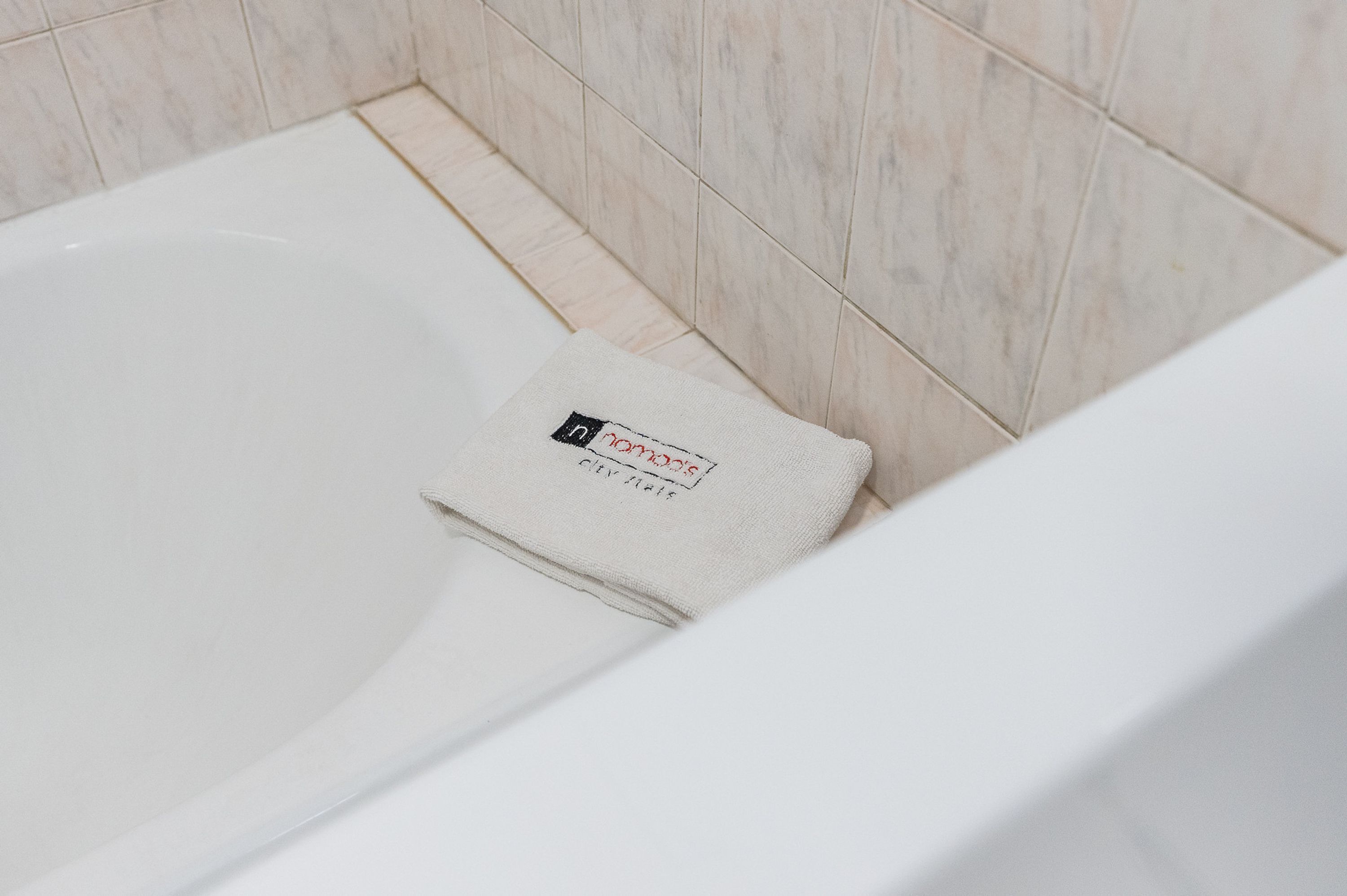 A white bathtub with a folded towel placed on the edge.