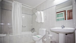 Ein Badezimmer mit Badewanne, Toilette und Waschbecken.