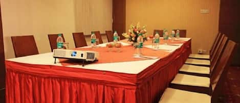 A conference room with a long table, chairs, a projector, and water bottles.