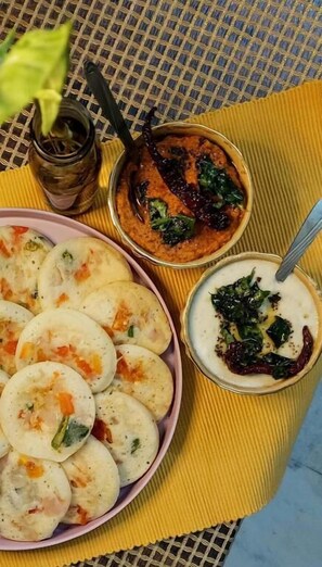 Ein Tisch mit Speisen, darunter ein Teller Knödel, eine Schüssel Curry und eine Schüssel Joghurt mit Spinat.