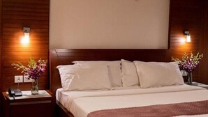 Una habitación de hotel con una cama, mesitas de noche y lámparas fijadas a la pared.