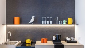 A modern kitchen with a built-in sink, a stove, and a countertop with various kitchen items. - Caracolé Luxury Suites (Naples)