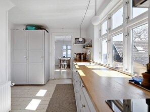 A kitchen with a wooden countertop, a sink, and a window with a view of the outside. - 5 Star Holiday Home in Svaneke (Svaneke)