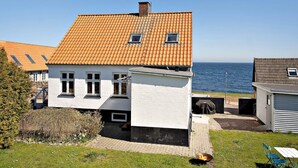 A coastal house with a tiled roof, white walls, and a small garden. - 5 Star Holiday Home in Svaneke (Svaneke)