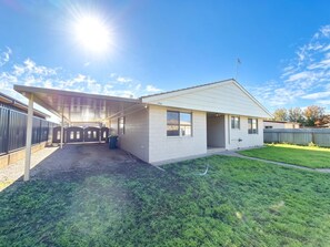 A single-story house with a covered patio area, a fenced yard, and a clear sky. - Spacious Cosy Family & Pet-Friendly Home with Large Backyard (Dubbo)