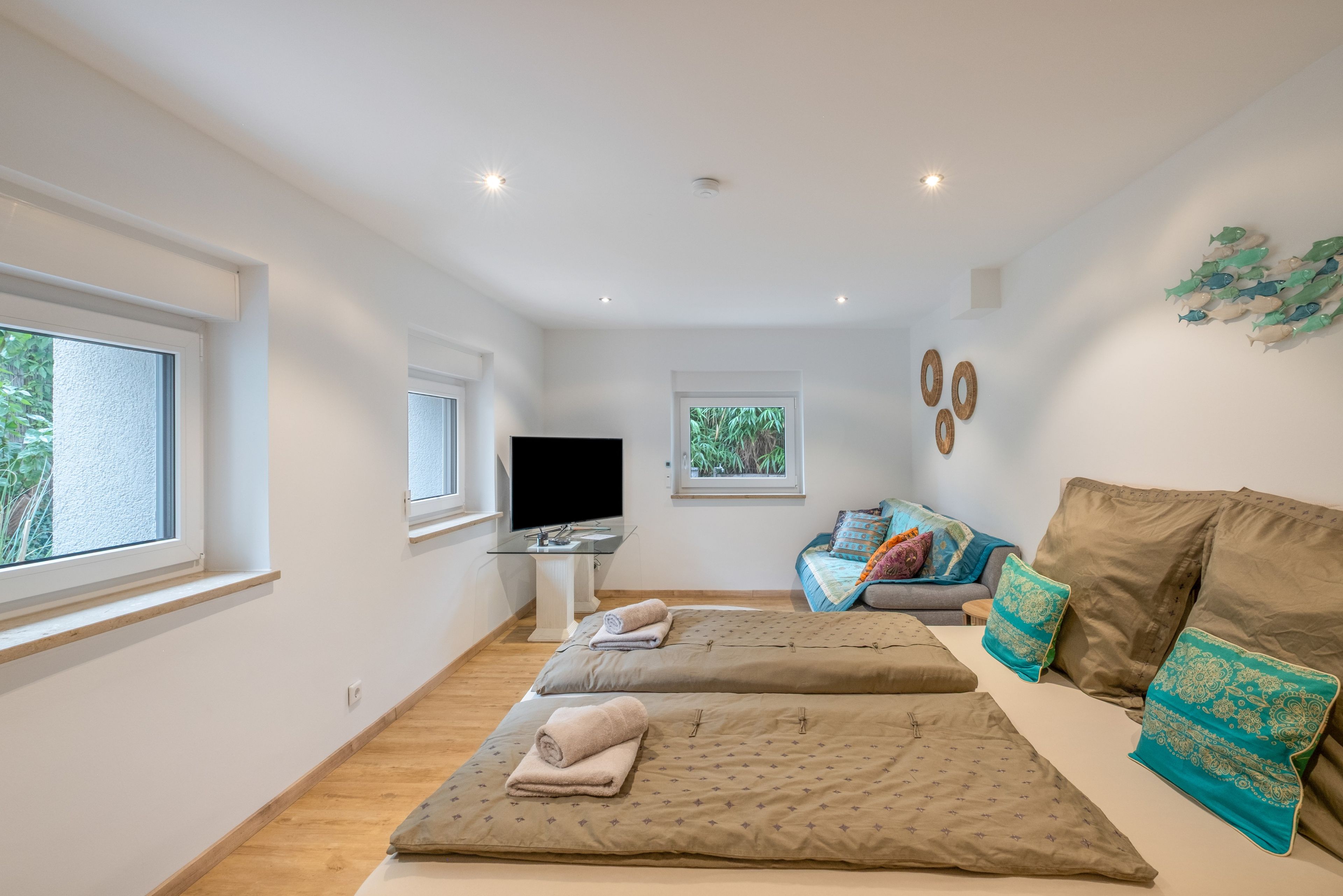 Une chambre moderne avec un lit, une télévision et un canapé.