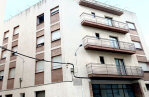 Um edifício com vários andares, varandas e janelas.