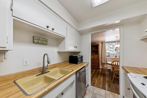 A compact kitchen with a sink, microwave, and wooden countertop. - 1168hc 3 Bedroom Condo (South Lake Tahoe)