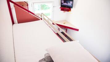 A room with a bed, a desk, a television, and a window.