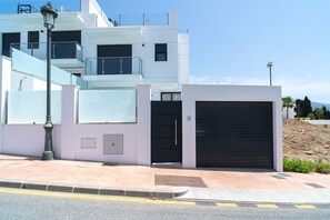 A modern building with a flat roof, a large garage door, and a staircase leading to an upper level. - Villa Casa Mezcal by Casasol (Nerja)